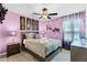 Comfortable bedroom with an ornate headboard, ceiling fan, mauve walls and dark grey trim at 1799 Tropical Palms Cir, Kissimmee, FL 34747