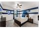 Charming bedroom with a blue and white striped accent wall, surfboard decor, and ceiling fan at 1799 Tropical Palms Cir, Kissimmee, FL 34747