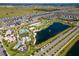 Aerial view of a community pool and recreation area surrounded by lush landscaping and a tranquil lake at 1799 Tropical Palms Cir, Kissimmee, FL 34747