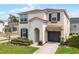 Charming two-story home featuring a well-manicured lawn, landscaped yard, and attached garage at 1799 Tropical Palms Cir, Kissimmee, FL 34747