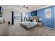 Serene main bedroom featuring a tray ceiling, plush carpet, a blue accent wall, and ample natural light at 1799 Tropical Palms Cir, Kissimmee, FL 34747