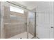 Contemporary shower with tiled walls, a glass door, a built-in niche, and a rainfall showerhead at 1799 Tropical Palms Cir, Kissimmee, FL 34747