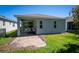 A covered patio area with brick pavers leads to a green backyard at 193 Old Moss Cir, Deland, FL 32724