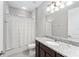 Well-lit bathroom featuring a granite vanity, neutral tones, and a shower-tub combo with striped curtain at 193 Old Moss Cir, Deland, FL 32724
