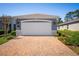 Two-car garage with brick paver driveway and manicured landscaping at 193 Old Moss Cir, Deland, FL 32724