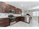 Modern kitchen featuring stainless steel appliances, including a gas range and island with a breakfast bar at 193 Old Moss Cir, Deland, FL 32724