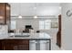 Kitchen island with gray granite countertop, stainless steel dishwasher, and view to the living room at 193 Old Moss Cir, Deland, FL 32724