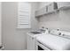 Well-lit laundry room with a front-load washer and dryer, and a shelf for extra storage at 193 Old Moss Cir, Deland, FL 32724