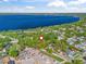 Aerial photo of a property near a large lake with mature trees and a well maintained lawn at 208 Hideaway Ct, Minneola, FL 34715
