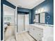 Stylish bathroom with blue walls, shower and tub combo, tile floors and white cabinets at 208 Hideaway Ct, Minneola, FL 34715