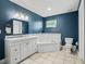 Stylish bathroom with blue walls, tile floors, tub and shower combo and white cabinets at 208 Hideaway Ct, Minneola, FL 34715