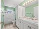 Green bathroom with tiled floors, plenty of cabinet space, and a shower and tub combo at 208 Hideaway Ct, Minneola, FL 34715