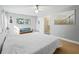 Bright bedroom with white walls, light wood floors, ceiling fan and a quaint blue loveseat at 208 Hideaway Ct, Minneola, FL 34715