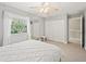 Sunlit bedroom with a white duvet, a window with curtains, and a closet for storage at 208 Hideaway Ct, Minneola, FL 34715