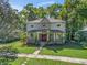 Charming two-story home featuring a welcoming front porch, lush landscaping, and a well-manicured lawn at 208 Hideaway Ct, Minneola, FL 34715