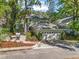 The side view of the property showcases the two car garage, screened in porch, and fire pit area at 208 Hideaway Ct, Minneola, FL 34715