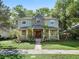 Charming two-story home with a stone accent tower and covered front porch surrounded by lush, mature trees at 208 Hideaway Ct, Minneola, FL 34715