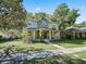 Charming two-story home with a stone accent tower and covered front porch surrounded by lush, mature trees at 208 Hideaway Ct, Minneola, FL 34715