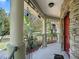 Inviting front porch with stone accents, wrought iron railings, and beautifully landscaped flower beds at 208 Hideaway Ct, Minneola, FL 34715