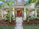 Inviting front porch with stone accents, wrought iron railings, and beautifully landscaped flower beds at 208 Hideaway Ct, Minneola, FL 34715