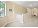 Upstairs hallway with neutral carpeting and a safety gate overlooking a bedroom at 208 Hideaway Ct, Minneola, FL 34715