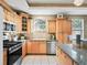 Well-lit kitchen features wood cabinets, stainless steel appliances, granite counters and a tile floor at 208 Hideaway Ct, Minneola, FL 34715