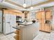 Kitchen showcasing tile floors, wood cabinets, granite countertops, and stainless appliances at 208 Hideaway Ct, Minneola, FL 34715