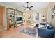 Sunlit living room showcasing hardwood floors, a modern shelving unit, and a blue sofa at 208 Hideaway Ct, Minneola, FL 34715