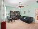 This living room has a ceiling fan, a dark blue couch, and is freshly painted with light green walls at 208 Hideaway Ct, Minneola, FL 34715
