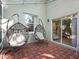 This screened-in patio is tiled and has two hanging chairs with views of the interior at 208 Hideaway Ct, Minneola, FL 34715