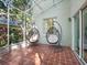 This screened-in patio has two hanging chairs with cushions, and a tiled floor at 208 Hideaway Ct, Minneola, FL 34715