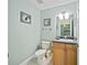 A clean powder room with a sink, toilet, and neutral decor at 208 Hideaway Ct, Minneola, FL 34715