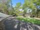 A street view of the property with lush green grass and lots of mature trees at 208 Hideaway Ct, Minneola, FL 34715