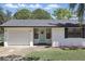 Charming single-story home featuring a manicured lawn, freshly painted white exterior and an attached garage at 211 Agua Vista St, Debary, FL 32713