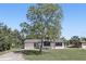 Charming single-story home featuring a manicured lawn, freshly painted white exterior, and mature trees at 211 Agua Vista St, Debary, FL 32713