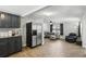 Open concept kitchen and living room with stainless steel refrigerator, gray cabinets and large sectional sofa at 211 Agua Vista St, Debary, FL 32713