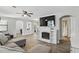 Open living room featuring wood-look floors, modern ceiling fan, fireplace, and easy access to other rooms at 211 Agua Vista St, Debary, FL 32713