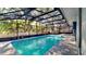 A screened-in pool features a ladder and landscaping along the exterior of the pool at 213 Almaden Ct, Winter Springs, FL 32708
