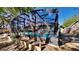 Screened-in pool from the backyard surrounded by tropical plants and clear blue skies above at 213 Almaden Ct, Winter Springs, FL 32708