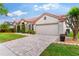 Charming single-story home boasting a red tile roof, paver driveway, and lush landscaping at 2359 Baronsmede Ct, Winter Garden, FL 34787