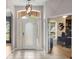Bright foyer with a decorative light fixture, arched transom window, and a view into the home office at 2359 Baronsmede Ct, Winter Garden, FL 34787
