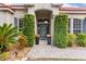 Inviting front entrance framed by elegant topiaries and a tiled walkway leading to a glass-paneled door at 2359 Baronsmede Ct, Winter Garden, FL 34787