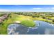 Scenic aerial view of a golf course with a water hazard and surrounding community at 2359 Baronsmede Ct, Winter Garden, FL 34787