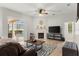 Comfortable living room featuring modern fireplace, neutral color palette, ceiling fan, and access to the lanai at 2359 Baronsmede Ct, Winter Garden, FL 34787