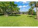 Expansive backyard with lush lawn and screen enclosed pool beyond the property line at 2922 Carmia Dr, Orlando, FL 32806