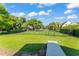 A well-maintained backyard featuring a lush lawn, mature trees, and an iron fence at 2922 Carmia Dr, Orlando, FL 32806