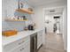 Wet bar featuring wine cooler, quartz counters, shaker cabinets and open shelves with decor at 2922 Carmia Dr, Orlando, FL 32806