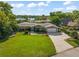 Charming one-story home featuring lush landscaping, a spacious driveway, and a picturesque lake view at 2922 Carmia Dr, Orlando, FL 32806