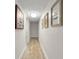 Hallway with hardwood floors and neutral walls decorated with Gathering photo frames at 2922 Carmia Dr, Orlando, FL 32806