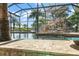 A screened-in pool with rock features and a slide as seen from the tiki bar at 2922 Carmia Dr, Orlando, FL 32806